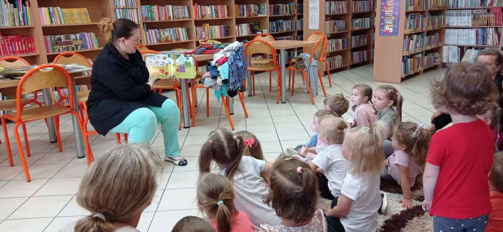 Bibliotekarka czyta opowiadanie przedszkolakom.