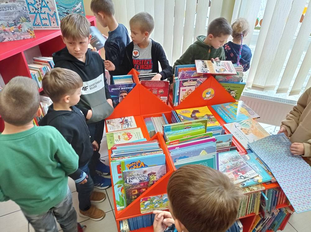 Dzieci przeglądają książki na półkach