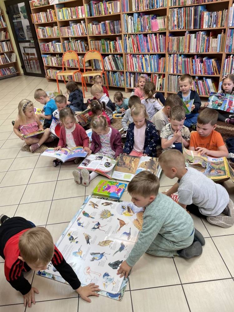 zdjęcie przedstawia dzieci przedszkolne przeglądające książeczki